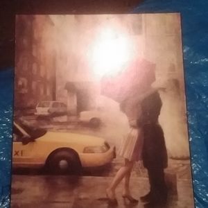 Picture of a woman hugging kissing a man holding a umbrella.